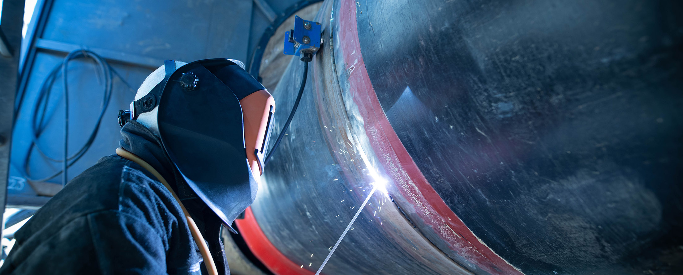 Professional welder welding pipe on a pipeline construction.